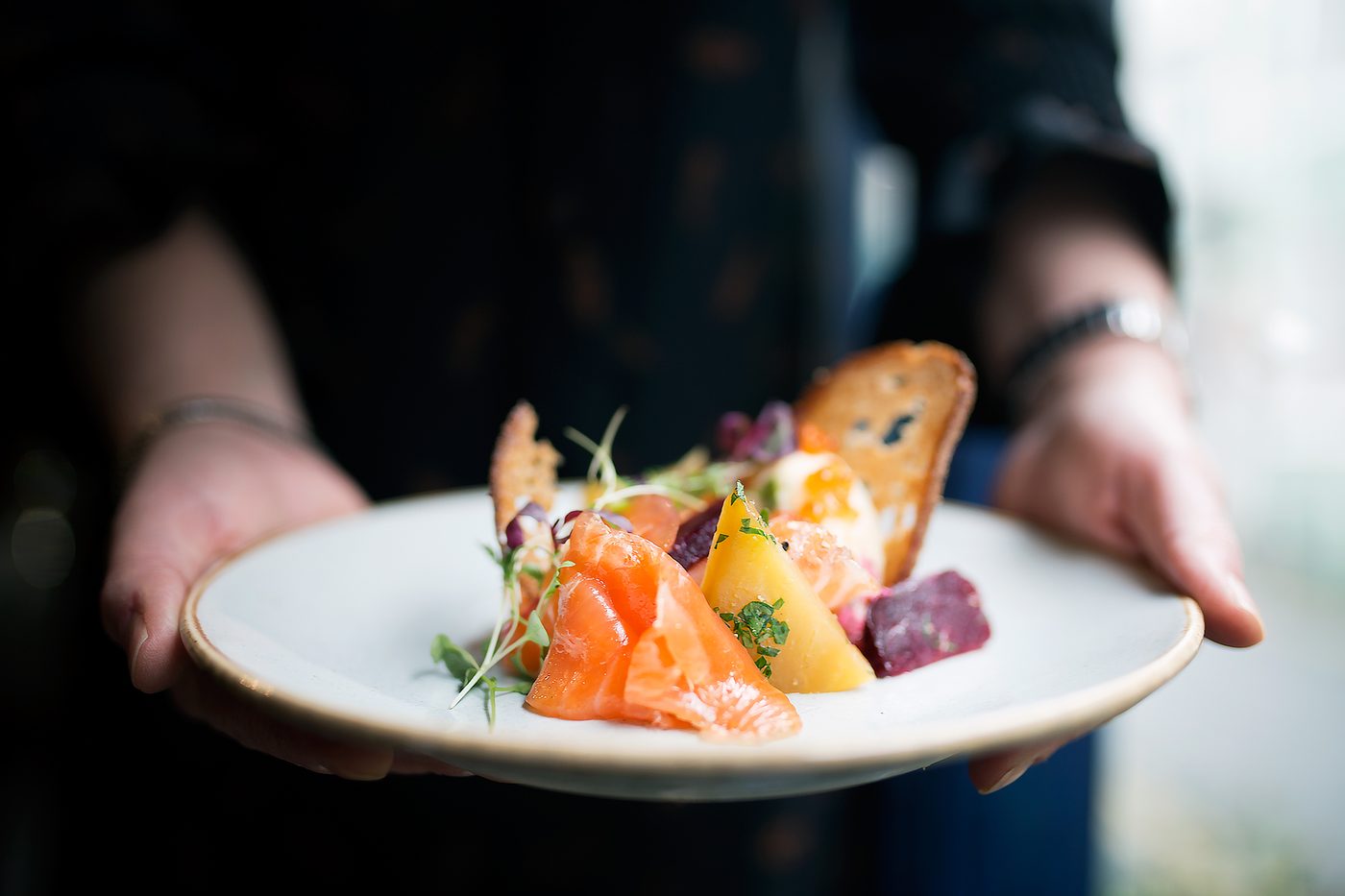 Cured salmon with blinis, brought to the table